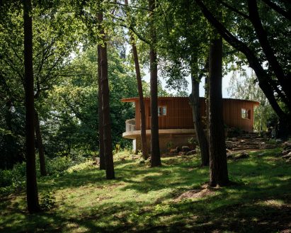 View of wood and concrete pool house by Surman Weston