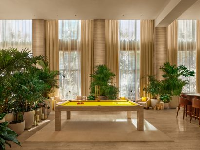 Custom travertine pool table with yellow top in the lobby