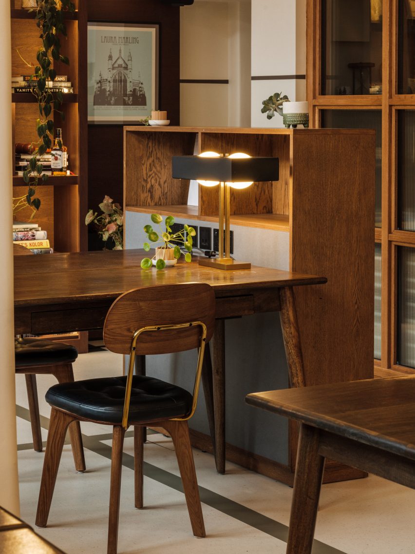 Flexible office space with white walls and floors, decorated with dark wood midcentury furniture