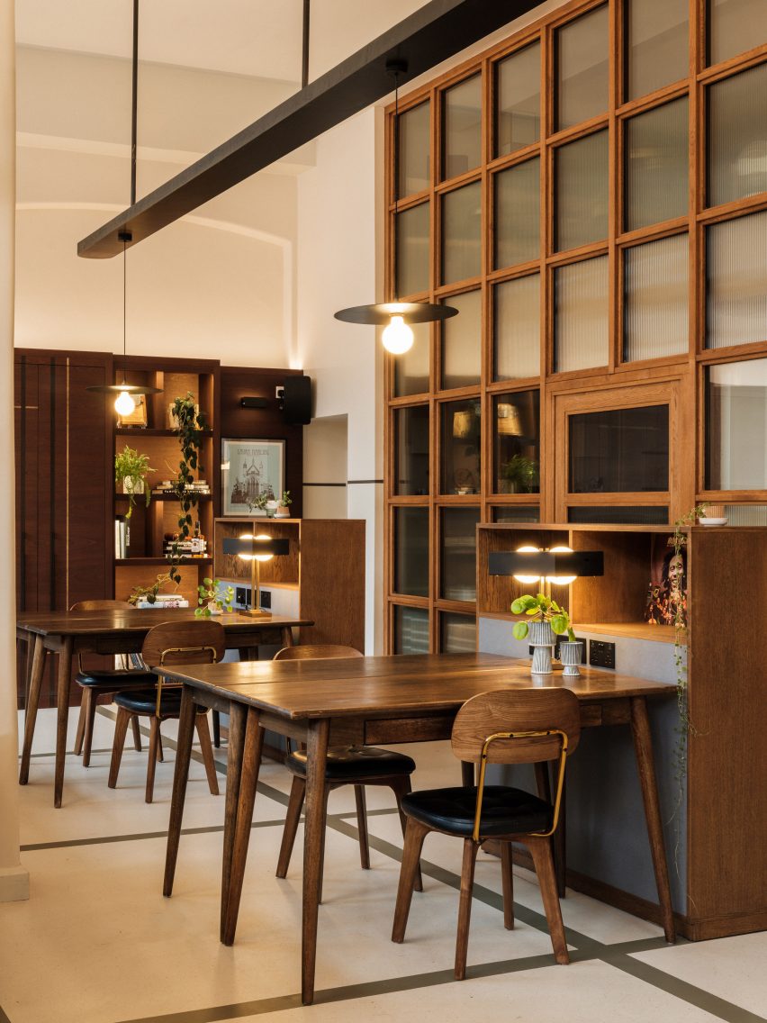 Flexible office space with white walls and floors, decorated with dark wood midcentury furniture