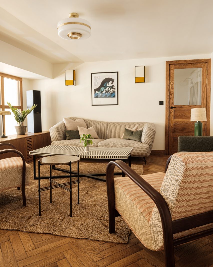 Lounge room with parquet flooring, grey sofa and cream armchair
