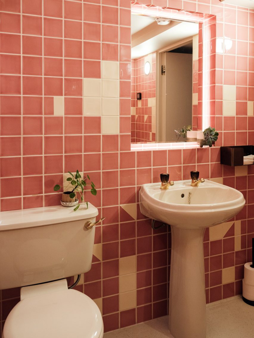 Bathroom with white sink and toilet and pink and white tiled wall