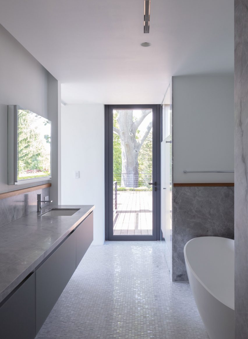 Bathroom interior with grey stone units and a mosaic floor