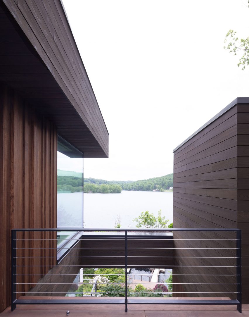 Elevated outdoor terrace overlooking a lake with an opening over a courtyard below