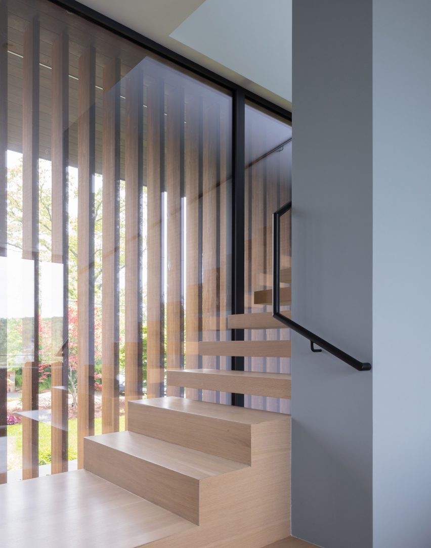 Timber floating staircase alongside a window with exterior timber slats