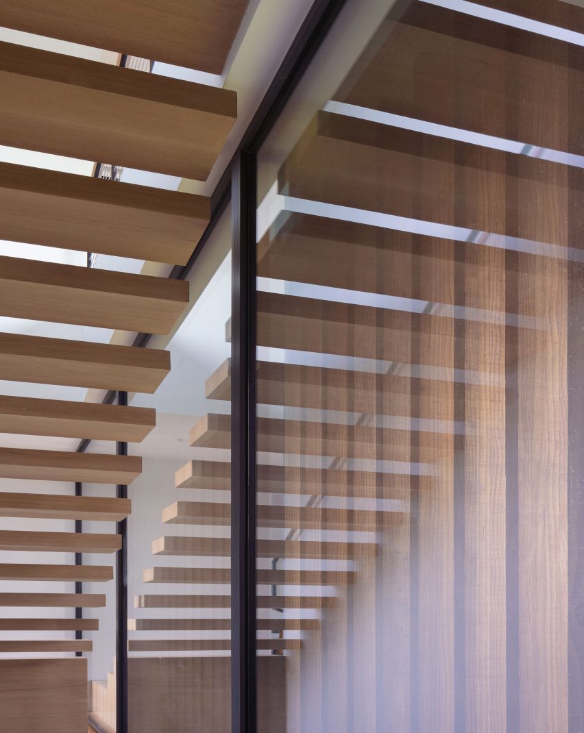 Timber floating staircase alongside a window with exterior timber slats