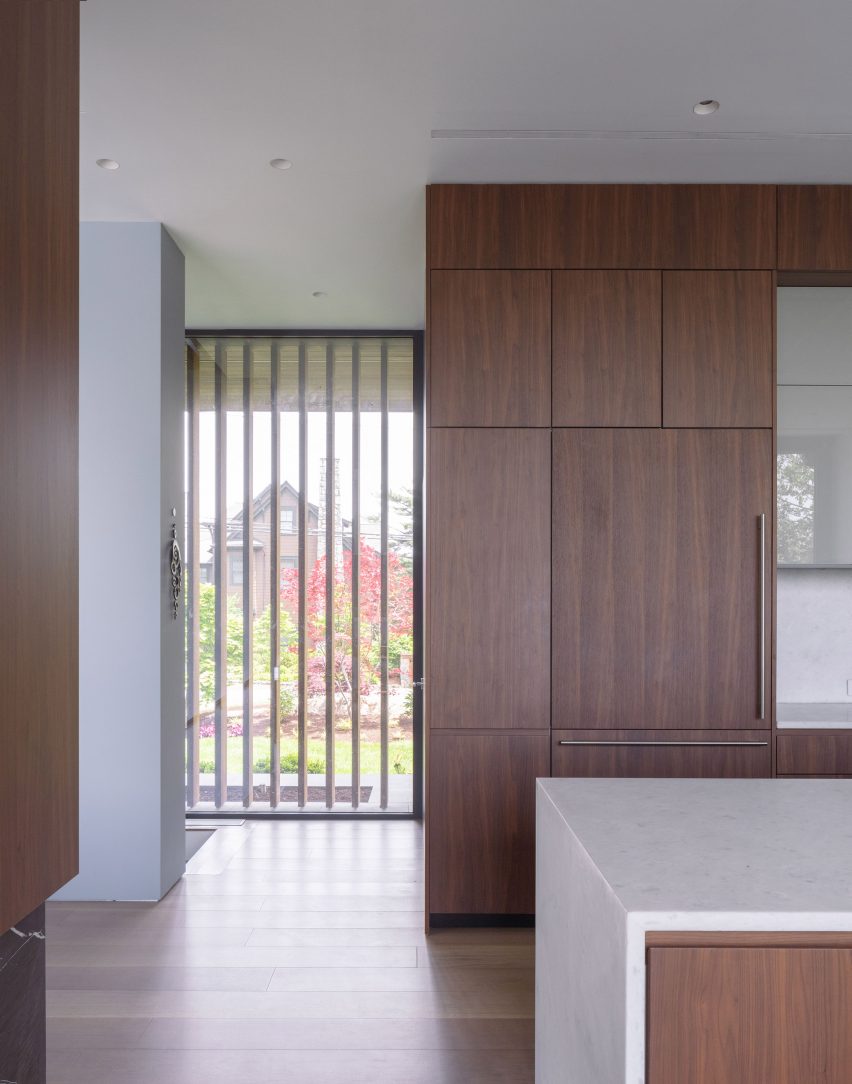 Interior of a kitchen with walnut cabinets and white granite worktops