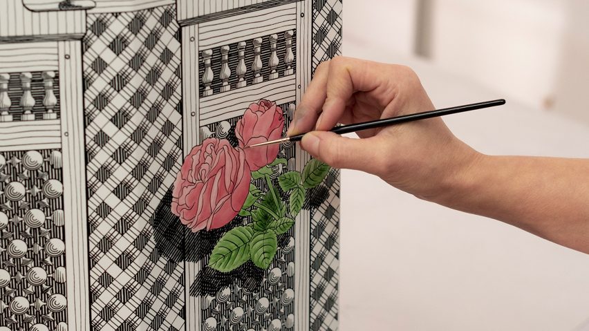 Photo of someone painting roses of Fornasetti furniture