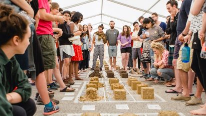 University of Arts Linz students in a tent gathered around material samples