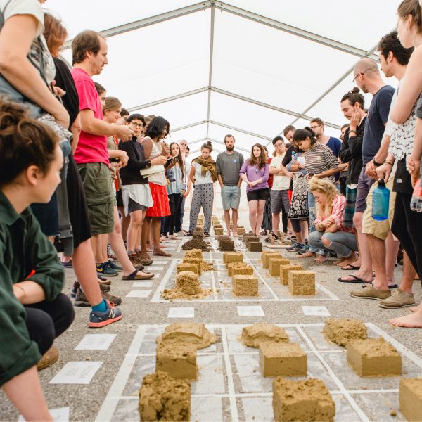 University of Arts Linz students in a tent gathered around material samples