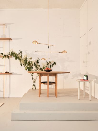 Wood table on a plinth with brass light above