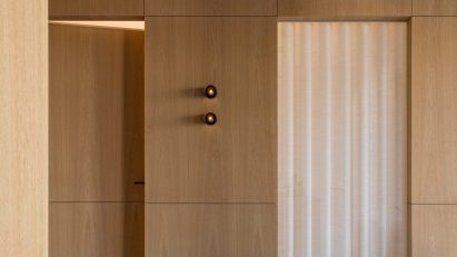 Photograph showing wood panelled space with doors hidden in the walls