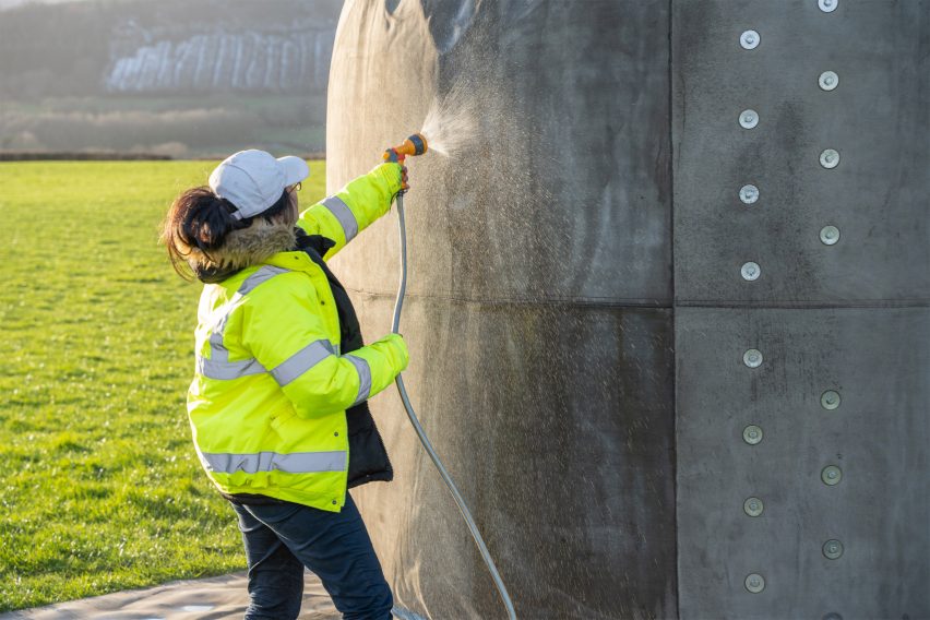 A woman spraying water on Deploy