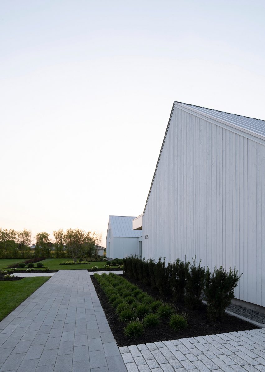 A white house with two gable ends in a garden