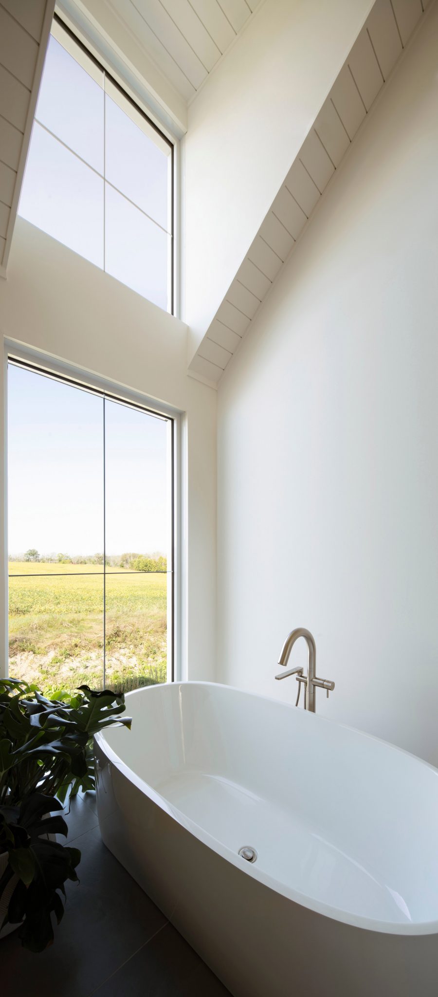 A bathroom with a freestanding bathtub and a window overlooking a garden