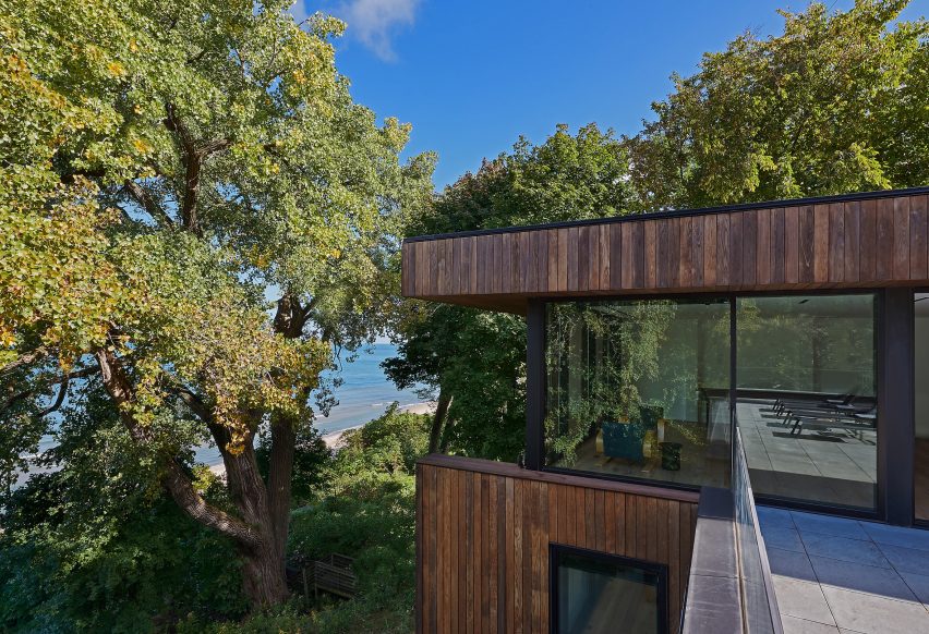 Top floor of a timber-clad home overlooking trees