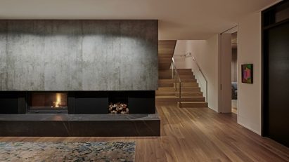 Interior space with a stone fireplace and wooden flooring