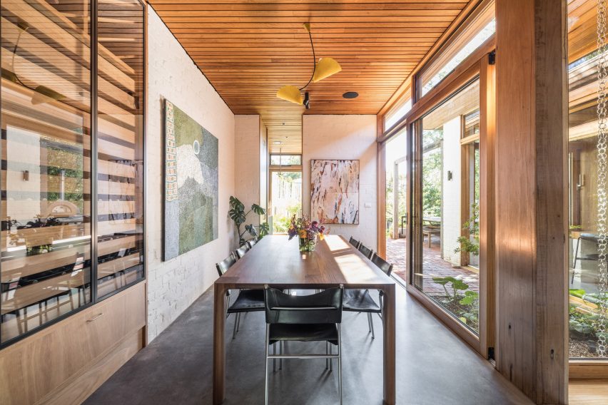 Dining room with dark flooring, wooden ceiling and a large dining table