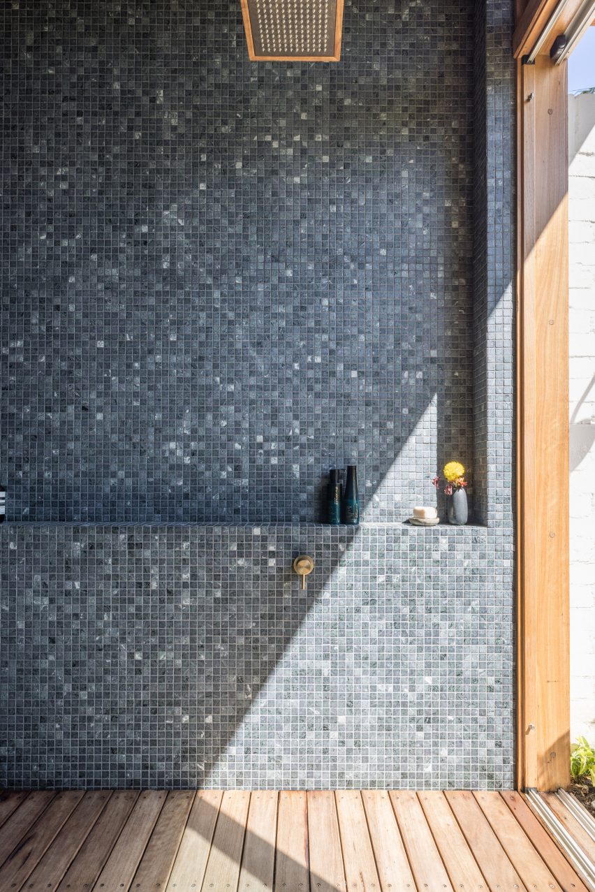 Bathroom with dark mosaic wall tiles and niche