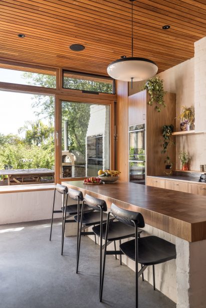 Kitchen with concrete flooring, wood ceiling and a large kitchen island with seating