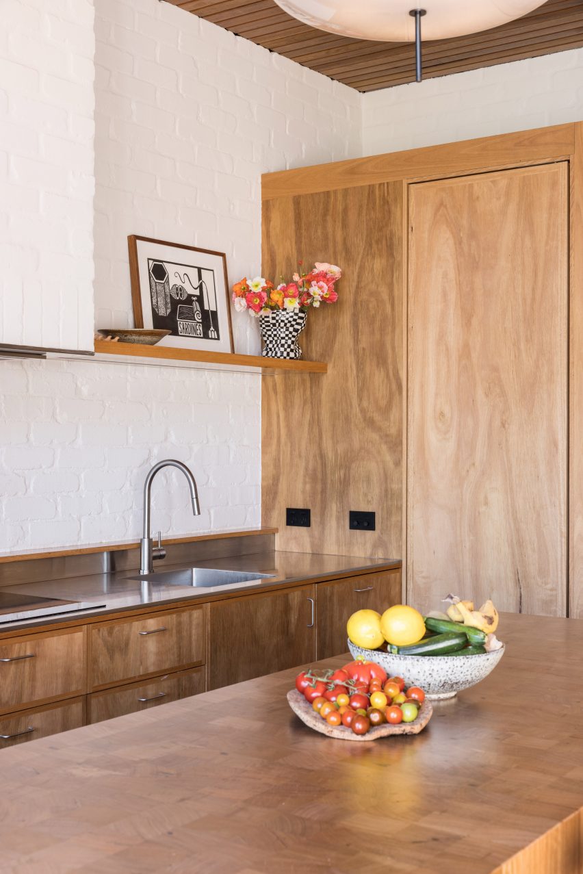 Kitchen with wood cabinets, central island and white walls