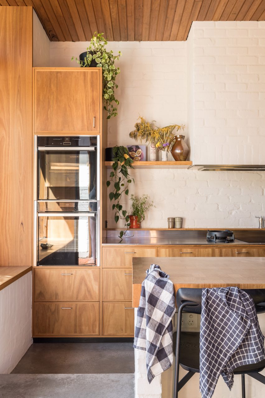 Kitchen with wood cabinets, central island and white walls