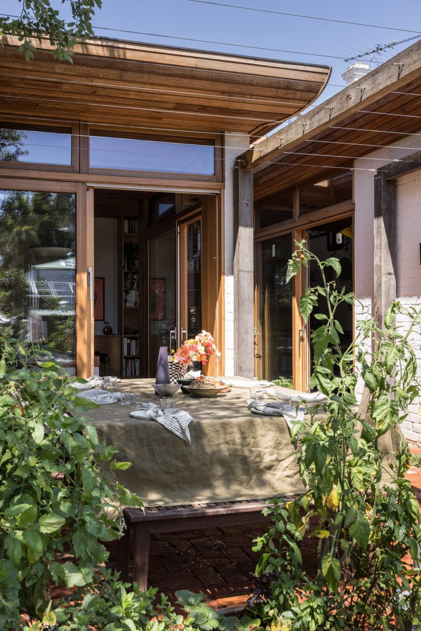 Outdoor dining space with a dining table and leafy planting