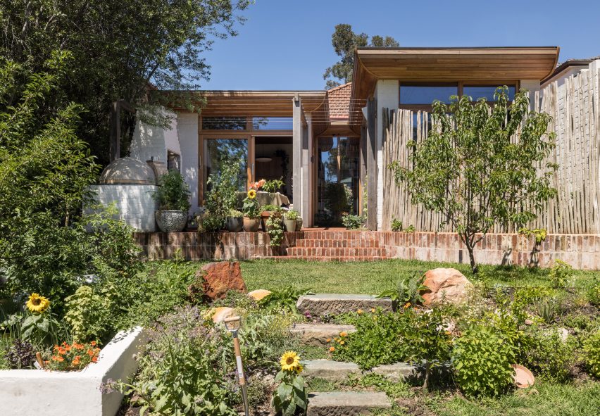 A grassy garden in front of a brick one-storey house