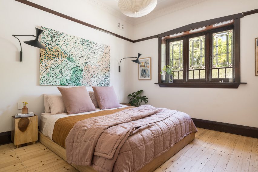 Bedroom with white walls, wood flooring and double bed with pink bedding