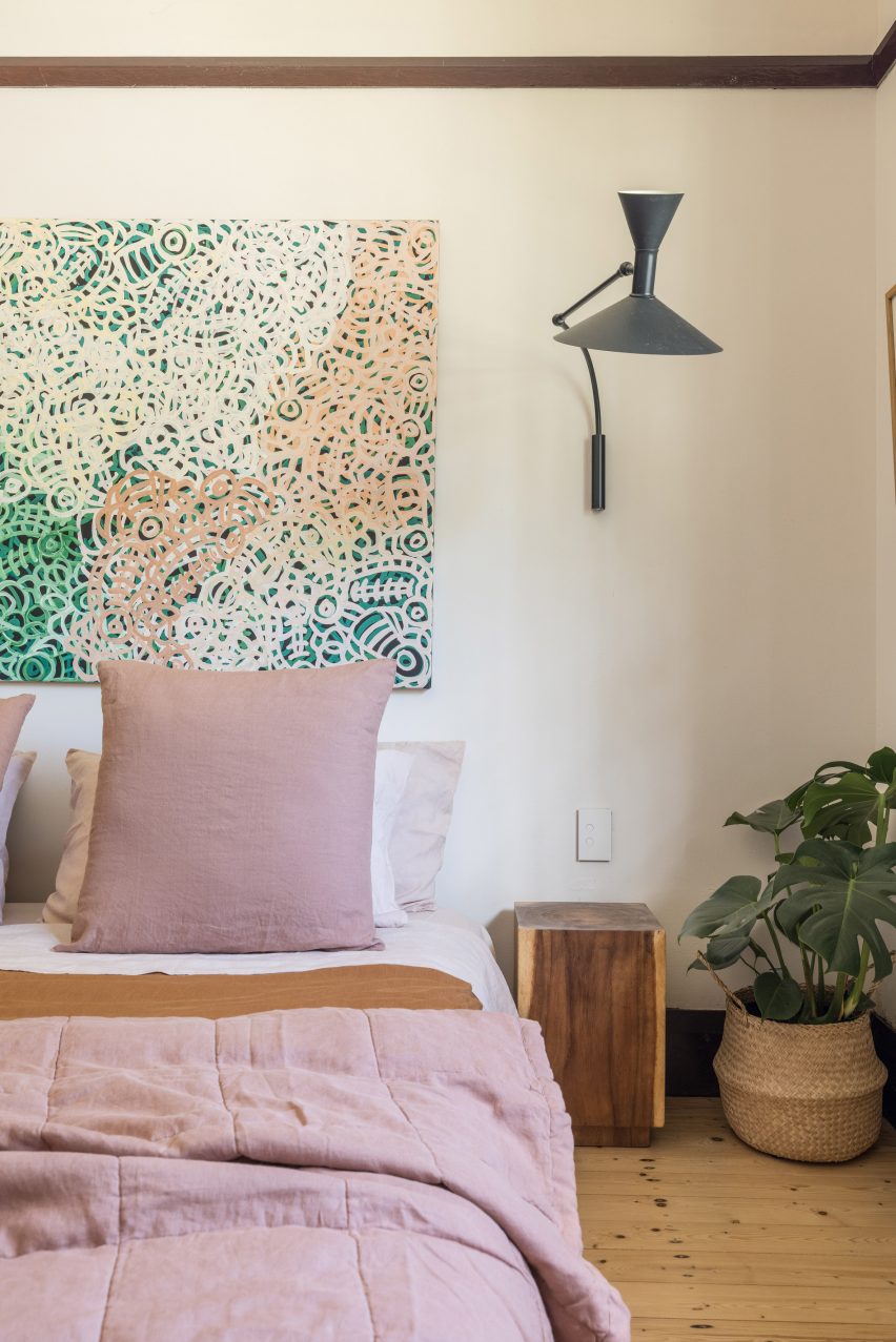 Bedroom with white walls, wood flooring and double bed with pink bedding