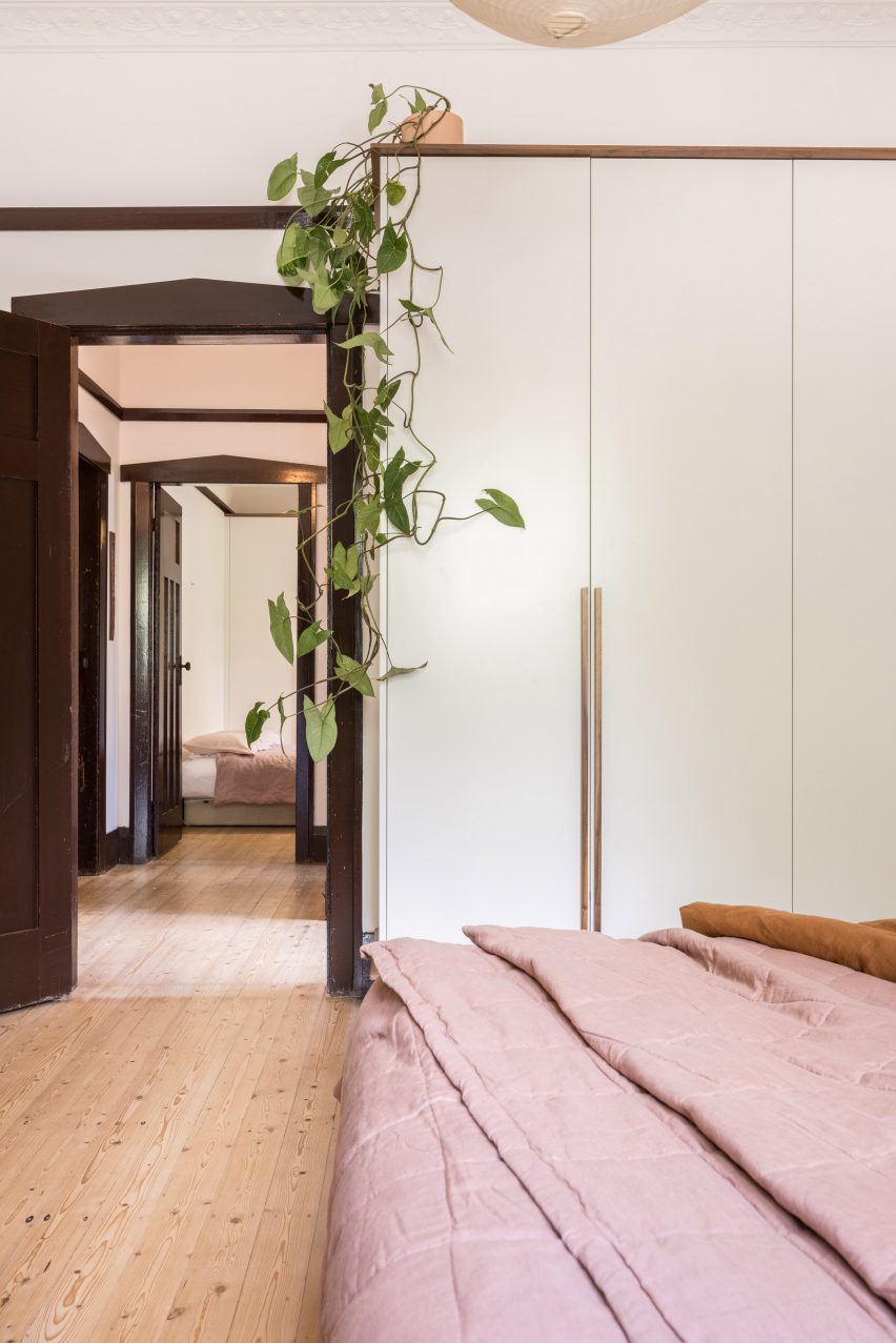 Bedroom with white walls, wood flooring and double bed with pink bedding