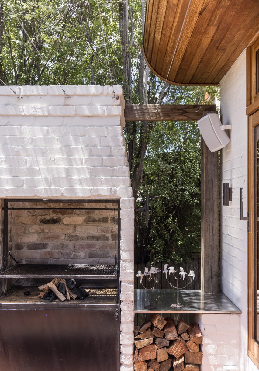 A white brick outdoor firing stove with logs