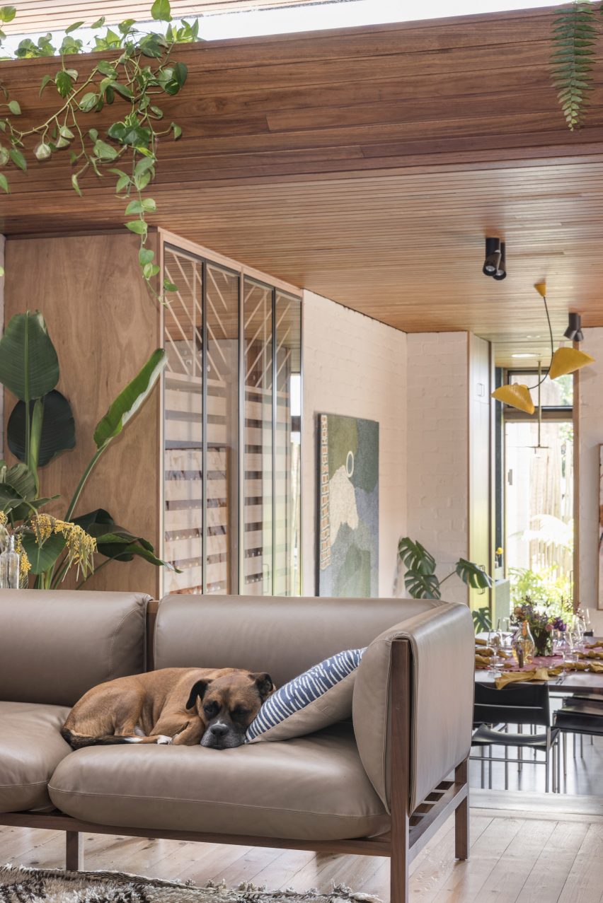 Living room with taupe sofa and wood flooring and ceiling