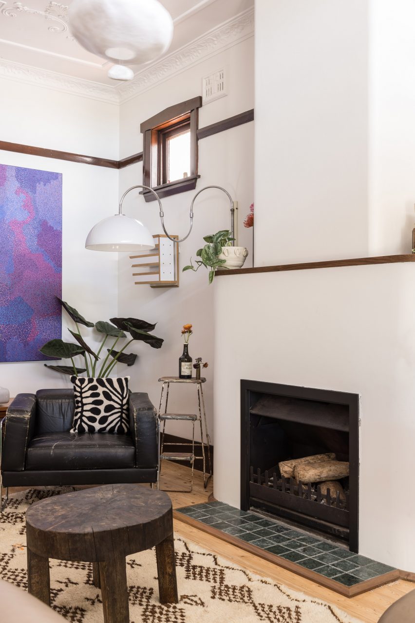 Living room with white walls, fireplace and black armchair