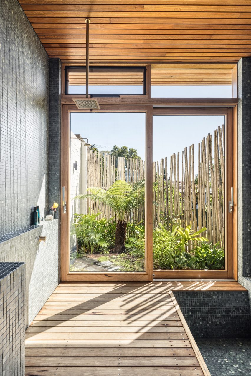 Bathroom with wood deck flooring and large windows overlooking a garden