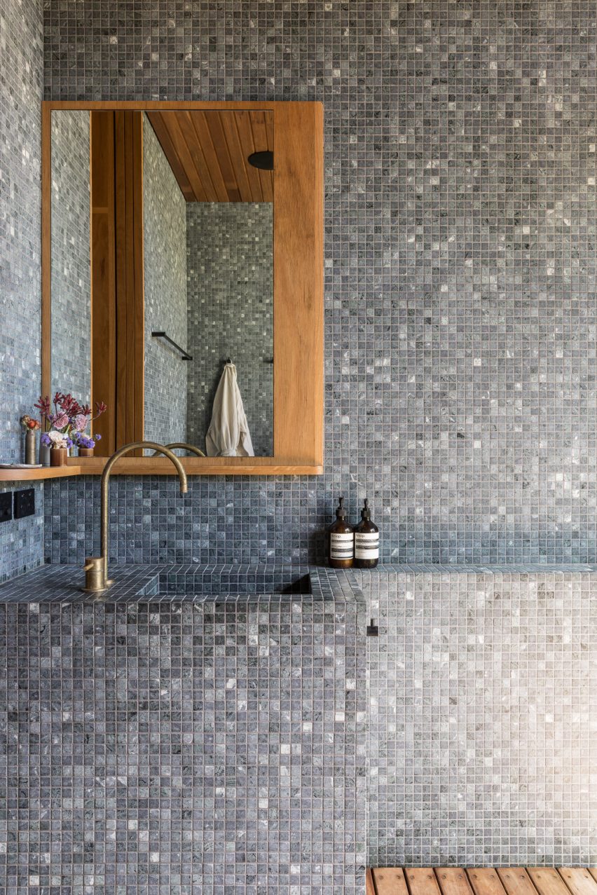 Bathroom with dark mosaic wall tiles and niche