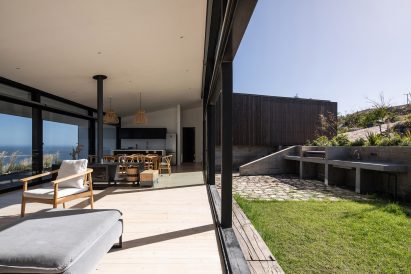 Interior of an open-plan living space with sliding glass doors leading to a grass garden