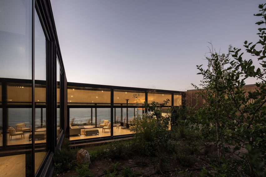 Exterior of a one-storey home with glazed walls revealing the open-plan living spaces