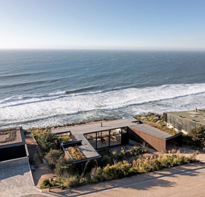 A U-shaped home on a hillside overlooking the sea