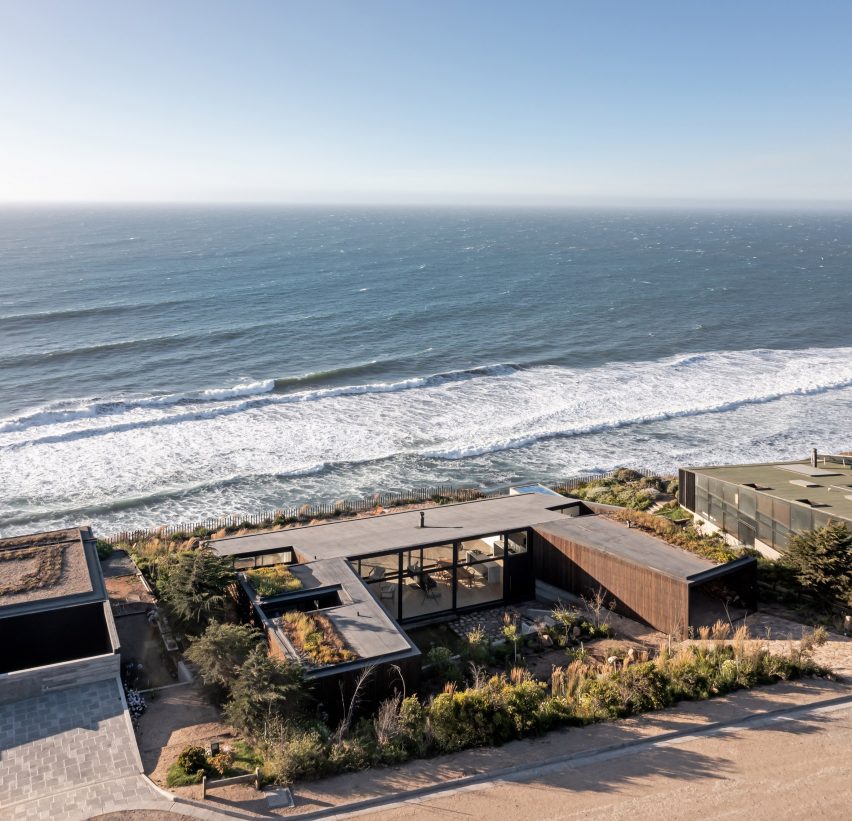A U-shaped home on a hillside overlooking the sea