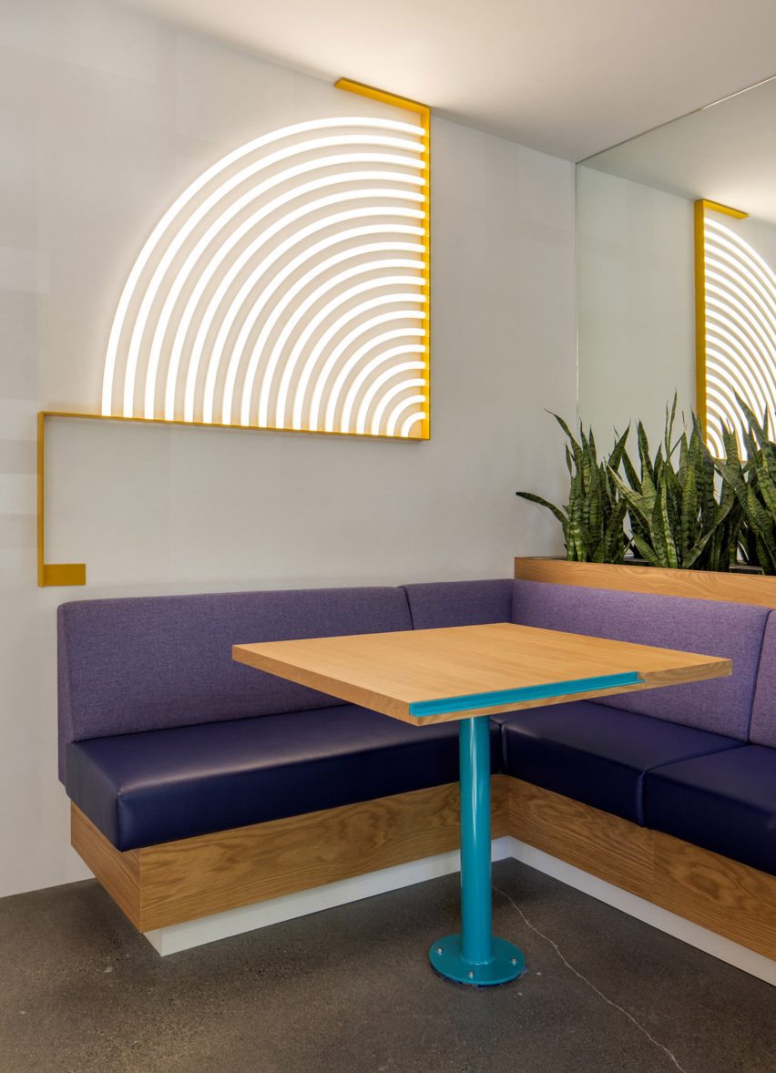 Purple banquette beneath illuminated graphic of concentric arcs