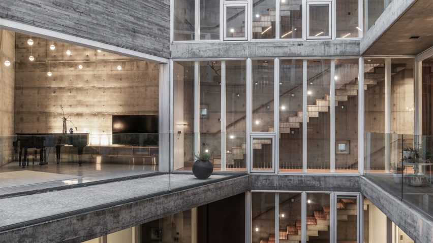 Three walls of a concrete and glass home surrounding a central courtyard