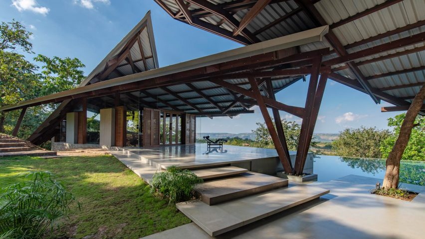 Outdoor terraces in a residential garden covered by angular metal canopies