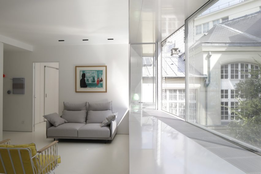 Open-plan living space with a grey sofa and floor-to-ceiling windows