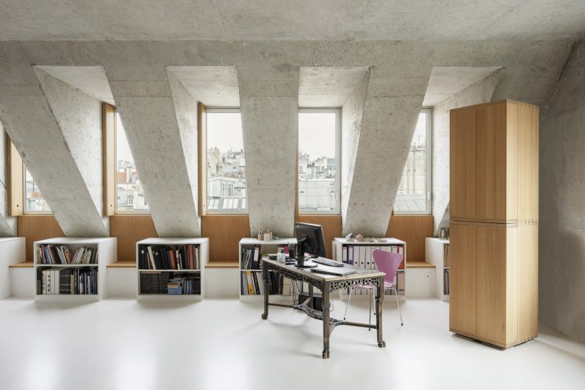 Interior of a concrete loft with freestaning storage and dormer windows