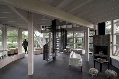 Off-centre metal and eucalyptus staircase within rounded house