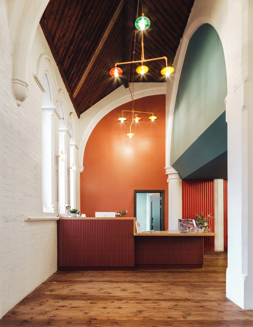 Orange wall and teal details inside community centre by Citizens Design Bureau
