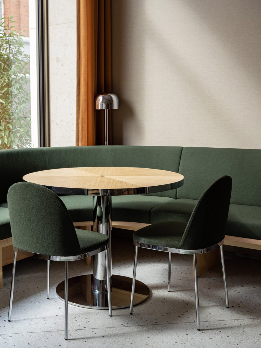 Restautant interior with green upholstered seating and wood tables