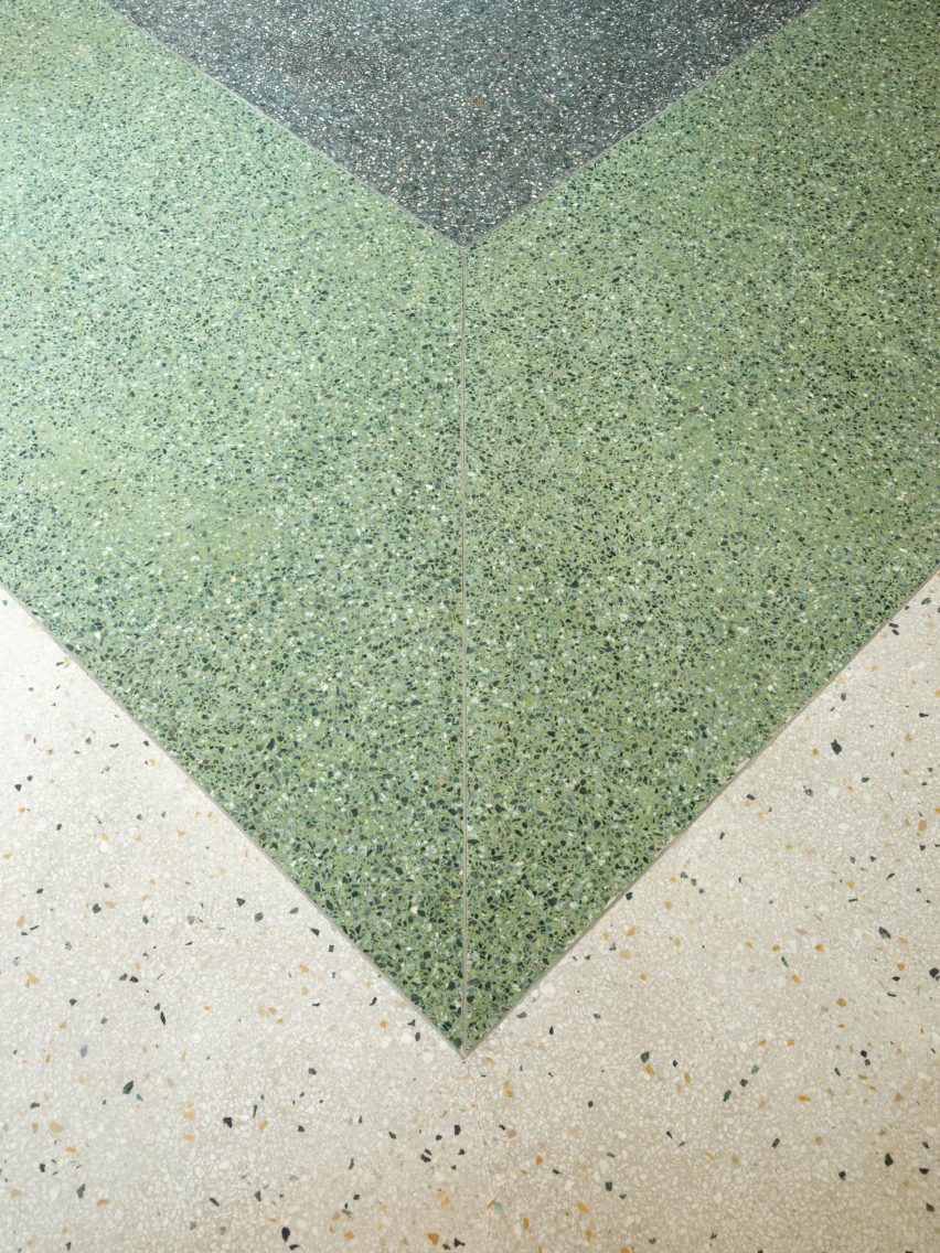 Terrazzo flooring in cream, green and deep green in a chevron pattern