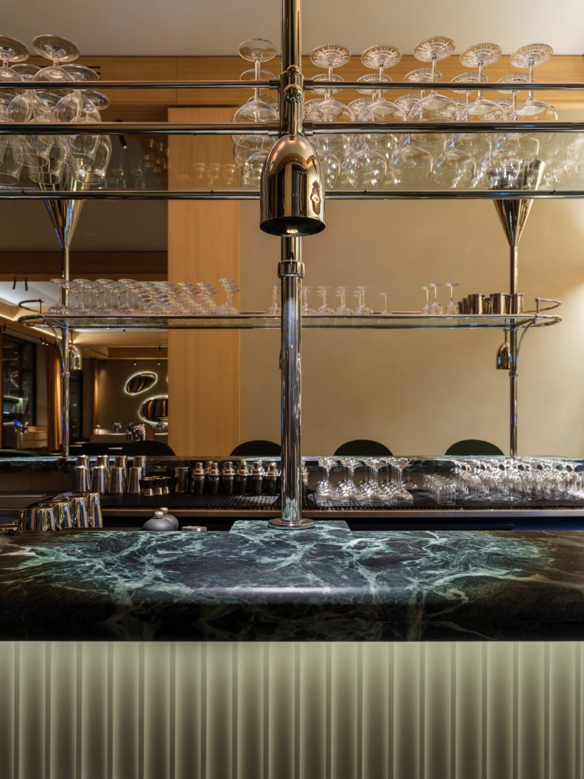 Restaurant bar with green marble countertop and stainless steel glass rack